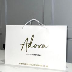 a white shopping bag with the name alora on it sitting on a counter top