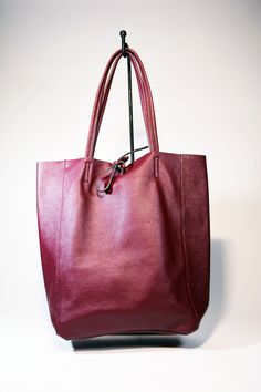 A lightweight and spacious Leather Shopper Tote Bag-Burgundy you can use for your office, gym and after-hours essentials while still looking stylish. Handmade from supple calfskin leather, the versatile look features over-the-shoulder handles and minimal detailing. Raw edges and no lining makes this style super light and easy to fold when traveling. Inside is a zippered document pouch and a leather cell phone pouch. Details: Color: BurgundyTwo leather strap for closing the bag.Natural unlined in Burgundy Shoulder Bag With Large Capacity For Daily Use, Burgundy Tote Shoulder Bag For Travel, Daily Use Large Capacity Burgundy Shoulder Bag, Burgundy Tote Bag For Travel, Versatile Burgundy Satchel Bag, Modern Burgundy Satchel For Daily Use, Burgundy Hobo Bag With Large Capacity For Travel, Burgundy Hobo Bag For Travel With Large Capacity, Burgundy Large Capacity Hobo Bag For Travel