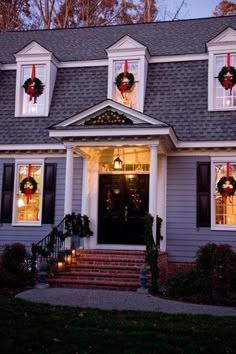 a house decorated for christmas with wreaths and lights