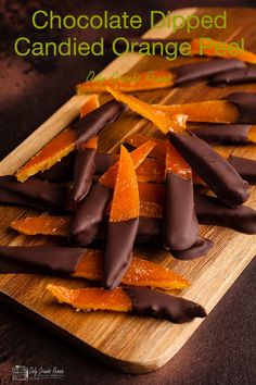 pieces of chocolate and orange peels on a wooden cutting board, ready to be eaten