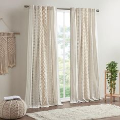 a living room with white curtains and rugs