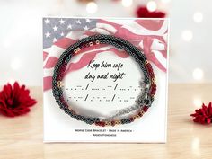 a card with two bracelets on it and an american flag in the back ground