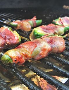 bacon wrapped jalapenos are cooking on the grill