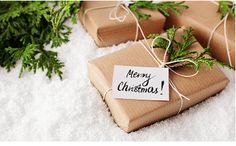 three presents wrapped in brown paper and tied with twine, sitting on white fur