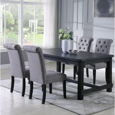 a dining room table with grey chairs around it