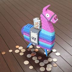 a llama made out of legos and some coins on a wooden table with the number 10