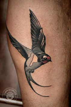 a black and white bird tattoo on the leg