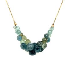 Moss aquamarine faceted briolettes are centered on a yellow gold chain, with the cluster of briolettes resting atop the clavicle when worn. This necklace is perfect to enhance the neckline or even to wear with a button-up shirt. The moss aquamarine in this necklace varies in color, with shades of sea green, moss green, light teal blue, and sky blue. Looking closer at these gorgeous hues, you will see specks of green from iron inclusions. Fun fact: Designer Rachel Atherley is a Montana native and Briolette Necklace, Earthy Jewelry, Montana State, Moss Aquamarine, Princess Necklace, Aquamarine Jewelry, Cluster Necklace, Sea Glass Necklace, Light Teal