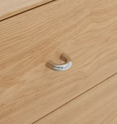 a close up of a drawer handle on a wooden cabinet with wood grained finish