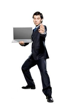 a man in a suit is holding a laptop