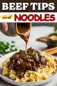 beef and noodles with sauce being drizzled over it in a white bowl