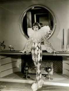 an old photo of a woman standing in front of a mirror