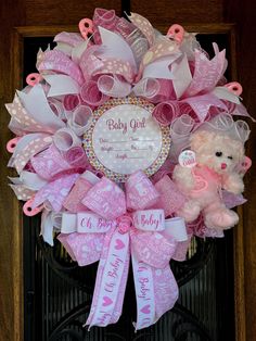 a baby girl wreath with pink and white ribbon, teddy bear and name on it