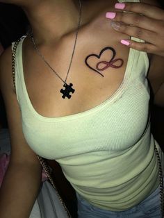 a woman with a cross and heart tattoo on her chest