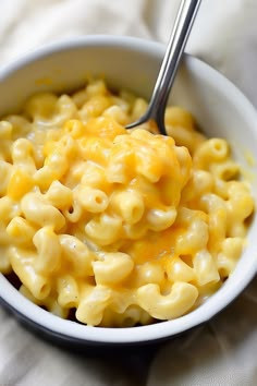 a white bowl filled with macaroni and cheese on top of a tablecloth