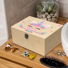 a wooden box sitting on top of a counter next to a hair brush and comb