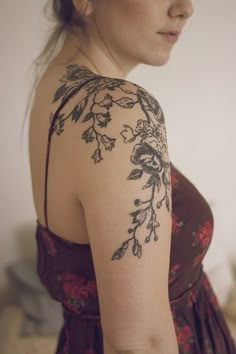 a woman with tattoos on her arm and shoulder