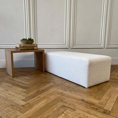 a white bench sitting on top of a wooden floor