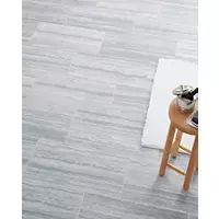 a wooden stool sitting on top of a hard wood floor next to a white rug