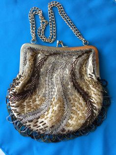 "Make an impression at any event with this sparkly gem of a handbag with a '20s vibe. Bronze, silver and gold beading sits atop light fabric with gold thread sewn in and hangs in loops at the bottom. The gold frame is spotless and the clasp works as it should. There is a pocket in the very clean yellow-gold interior, with the label Regale LTD. Chain can be used on shoulder or doubled for use on wrist. Slight musty smell from age/storage. Perfect for holiday parties, weddings, or any special (or Mid Century Planter, New Years Wedding, Gold Interior, Bronze Gold, Gold Thread, How To Make Handbags, Gold Threads, Vintage Handbags, Silver And Gold