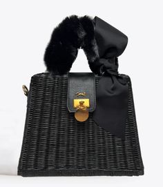 MME.Mink Winter Monaco Petite Fur Bag in Noir Our most popular wicker bag is back for Fall/Winter 2022 dressed up! Our Monaco Bag is this season's fanfare piece, inspired by Grace Kelly's glamorous lifestyle on the Riviera. This bag's clam-shell opening securely closes with a snap feature and the simple interior is a lightweight organic twill with a slip pocket. SIZE: 10"W x 11"H x 5"D Material: Organic Woven Wicker Tote with twill lined interior. Chic Straw Bag With Top Handle, Luxury Straw Bag With Top Carry Handle, Elegant Straw Bags With Bamboo Handle, Elegant Straw Beach Bag, Chic Black Straw Bag, Chic Straw Shoulder Bag, Elegant Woven Top Handle Straw Bag, Evening Straw Tote Bag With Detachable Handle, Elegant Woven Straw Top Handle Bag