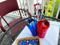 an outdoor table with patriotic decorations and utensils on it, along with a red white and blue napkin