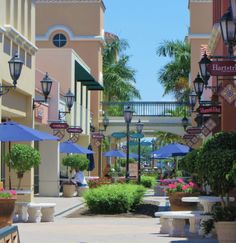 an empty street lined with tables and umbrellas