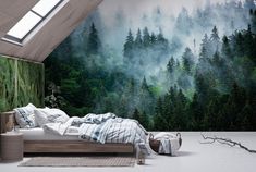 a bed sitting under a window in a bedroom next to a forest wallpaper mural