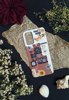 a cutting board sitting on top of a piece of paper next to shells and flowers