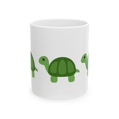 a white coffee mug with green turtles on it