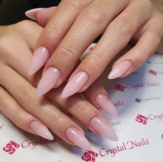 a woman's hands with long pink nails on top of her manicures