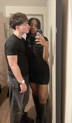 a man and woman taking a selfie in front of a mirror while standing next to each other