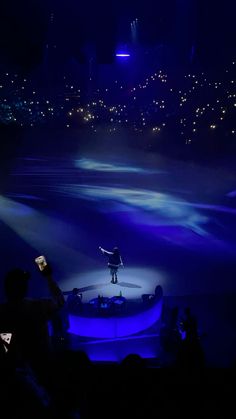 a man standing on top of a stage holding a cell phone