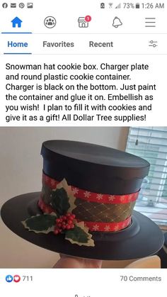 a person holding up a black hat with holly berries on it and the caption reads, snowman hat cookie box charger plate and round plastic cookie container container