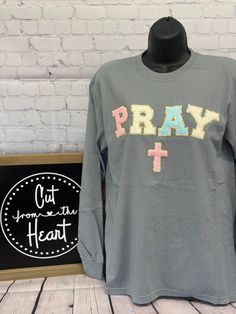 Welcome To Cut From The Heart!  This listing is for (1) chenille patch Pray t-shirt, long sleeve OR sweatshirt.  *Shirt Color Is Gray*  Please see the drop-down menu for options. This design is offered in standard (Tultex or Gildan) or premium brand (Comfort Colors).  *Note that the Comfort Colors size chart is the same as the Gildan/Tultex as they are owned by the same manufacturer*  *Please note that due to out-of-stock issues the t-shirt brand shown in the listing photo may be swapped to a similar brand.  * Design is a actual chenille patch.  * Sizes Available Are Listing In The Drop Down Menu.  * All items are made to order, therefore we do not accept refunds or exchanges. * Processing times are 7-10 business days + shipping. * We offer group discounts and wholesale pricing - just ask! Gray Long Sleeve Pre-shrunk T-shirt, Gray Tops With Embroidered Graphics For Streetwear, Gray Embroidered Streetwear Tops, Gray Embroidered Tops For Streetwear, Long Sleeve Cotton T-shirt With Embroidered Graphics, Cotton Long Sleeve T-shirt With Embroidered Graphics, Cotton Long Sleeve Tops With Letter Patch, Gray Screen Print Tops For College, Chenille Patch Ideas