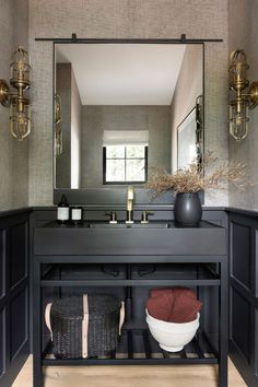 there is a large mirror above the sink in this bathroom with black cabinets and drawers