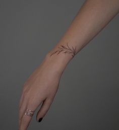 a woman's hand with a small tattoo on the middle of her left arm