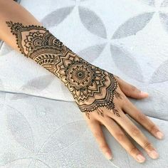 a woman's hand with henna tattoos on it