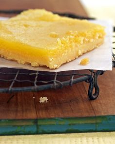 a piece of yellow cake sitting on top of a table next to a wire rack