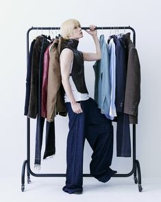 a woman standing in front of a rack with clothes