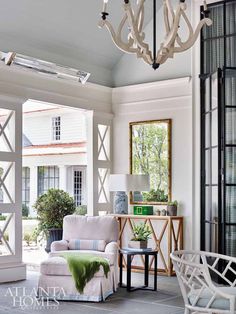 a living room filled with furniture and a chandelier hanging over the top of it