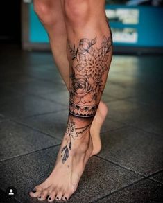 a woman's legs with tattoos and flowers on them