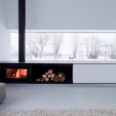 a living room filled with furniture and a fire place next to a couch in front of a window