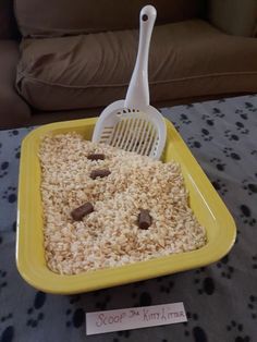 a yellow bowl filled with oatmeal next to a white spatula on top of a table