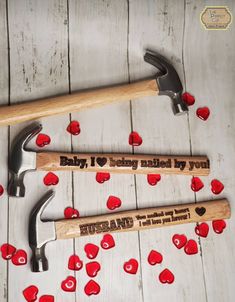 two hammers and some hearts on a wooden floor with the words baby, i love being married by you