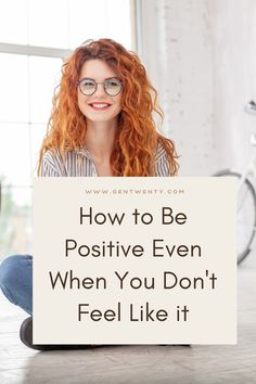 a woman sitting on the floor holding a sign that says how to be positive even when you don't feel like it