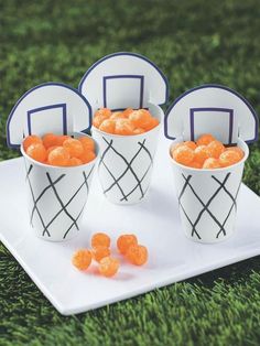 four buckets filled with orange candies on top of a white plate