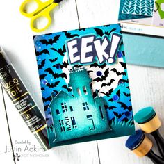 a halloween card with scissors, glue and some other crafting supplies on the table