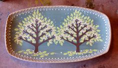 a decorative plate with trees painted on it