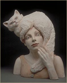 a statue of a woman with a cat on her head and hands in front of her face